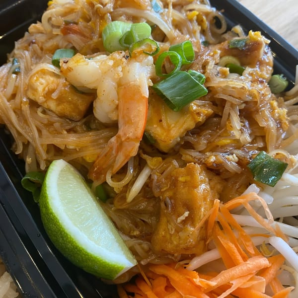 Close-up of Ping Yang Thai Grill and Dessert's Pad Thai with shrimp, tofu, lime, and vegetables.